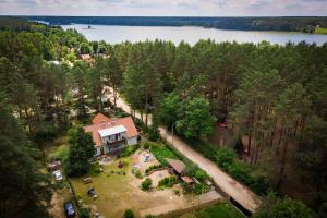 una vista aérea de una casa en el bosque junto a un lago en Mazurska Leśniczówka Nowy Zyzdrój, en Nowy Zyzdrój
