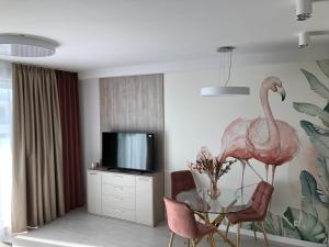 a living room with a glass table and pink chairs at Rogowo Pearl 1510 in Rogowo