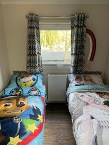 een slaapkamer met twee bedden en een raam bij Luxe Chalet Hoenderloo Airco, Netflix - Recreation Only in Hoenderloo