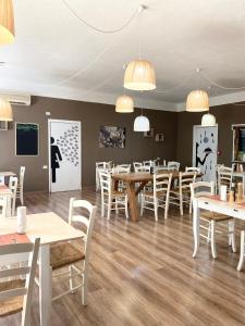 a restaurant with wooden tables and white chairs at Green Gallery Hotel and Restaurant in Muravera +59 photos