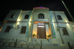 a large white building with a door at night at Bukhara Baraka Boutique Hotel in Bukhara