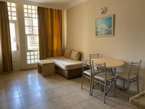 a living room with a table and chairs and a couch at İSABELLA APART OTEL in Alanya