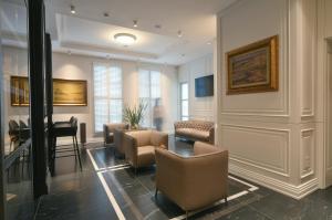 a waiting room with chairs and a table and a piano at VIZUALIZA Residence Hotel by HMG in Plovdiv