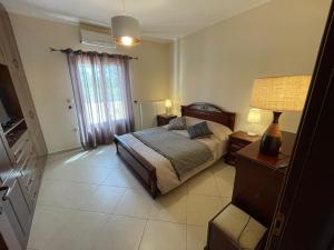 1 dormitorio con cama, lámpara y ventana en Villa Stelianna, en Engares