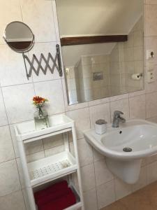 uma casa de banho branca com um lavatório e um espelho em Apartmán Silvia em Komárno