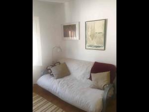 a bed with white sheets and pillows in a room at Apartamento luminoso y acogedor Port de la Selva in Port de la Selva
