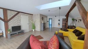 un soggiorno con divano giallo e TV di Appartement Köck 110qm a Reisbach