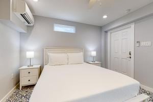 a bedroom with a large white bed and two lamps at Sweet Studio Suite in Rockport