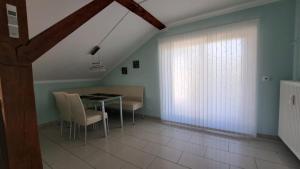 una sala da pranzo con tavolo, sedie e finestra di Appartement Köck 110qm a Reisbach