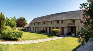 an old stone barn with a green yard at Domaine Malar in Guillerval