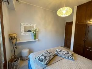 1 dormitorio con 1 cama con 2 almohadas y espejo en Villa Stelianna, en Engares