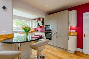 a kitchen with a glass table and red walls at Caradoc in Chepstow