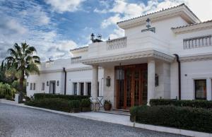 un edificio blanco con una puerta roja en una calle en Hotel Villarocamar, en Mijas