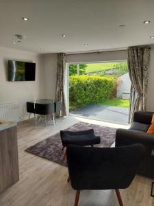 a living room with a couch and a table at Glenwood luxury Cottage Betws-y-coed in Betws-y-coed