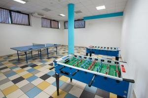 a room with two tables and ping pong tables at Ostello Ipsia in San Benedetto del Tronto