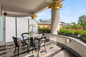 a patio with a table and chairs on a balcony at Hotel Continental in Oslo