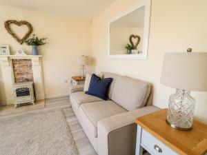 a living room with a couch and a fireplace at 5 Ffordd Y Meillion in Llanelli