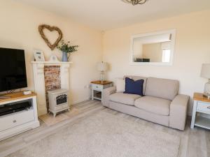 a living room with a couch and a tv at 5 Ffordd Y Meillion in Llanelli