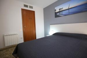 サロウにあるCOSTA DAURADA APARTAMENTS - Laresmanのベッドルーム1室(ベッド1台付)、木製のドア