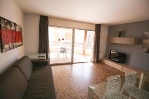 サロウにあるCOSTA DAURADA APARTAMENTS - Laresmanのソファとガラスのテーブルのあるリビングルーム