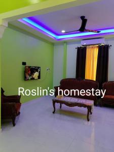 ein Wohnzimmer mit einem Sofa und einem TV an der Decke in der Unterkunft Roslin's Homestay in Kota Bharu