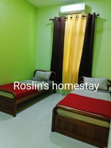 ein Schlafzimmer mit zwei Betten und einem Schild mit der Aufschrift „Roishi Homes Homesay“ in der Unterkunft Roslin's Homestay in Kota Bharu + 6 Fotos