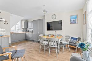 a kitchen and dining room with a table and chairs at Captains Cottage - Stylish cottage, level location, in the heart of Dartmouth in Dartmouth