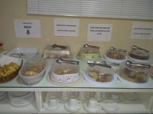 a shelf filled with dishes and other food items at Hotel Vale do Sol in Votuporanga