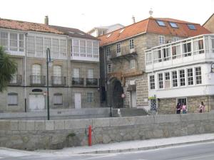 a large stone building on the side of a street at VIVIENDA TURÍSTICA Bajo, 7 Escaleras in Laxe