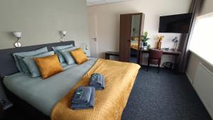 a bedroom with a bed with two pairs of slippers on it at Hotel Rozenburg in Rozenburg