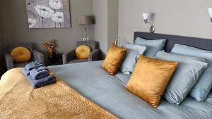 a bedroom with a large bed with blue and yellow pillows at Hotel Rozenburg in Rozenburg