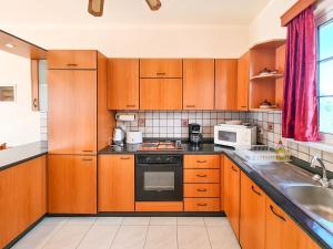 a kitchen with wooden cabinets and a stove top oven at Colonial Studio/Apartment in Faliraki