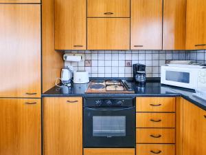 a kitchen with a stove and a microwave at Colonial Studio/Apartment in Faliraki
