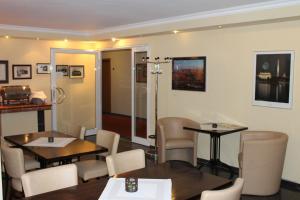 un restaurante con 2 mesas y sillas en una habitación en Hotel America, en Ramstein-Miesenbach