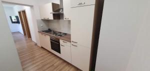 cocina con armarios blancos y fogones en Apartment Podkuze, en Mojstrana