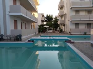 a swimming pool in front of a building at Residence Hotel Claudia in Alba Adriatica