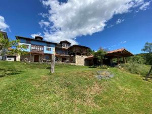 Casa Rural El Bohío في أريونداس: منزل كبير على قمة تلة عشبية