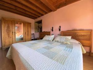 a bedroom with a large bed with a wooden headboard at Casa Rural El Bohío CA-846-AS in Arriondas