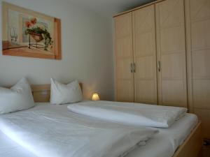 ein Schlafzimmer mit einem großen weißen Bett mit weißen Kissen in der Unterkunft Ferienwohnung T7 in Graal-Müritz