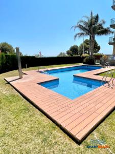 邁阿密普拉特亞的住宿－APARTBEACH PANORAMIC VISTAS PLAYA y PISCINA，庭院中带木甲板的游泳池