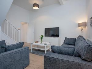 a living room with two couches and a tv at 1 primrose mews in Torquay