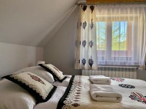 a bedroom with a bed with pillows and a window at Willa "NA KLINKU" in Dzianisz