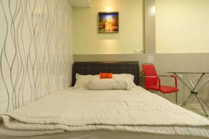 a bedroom with a bed and a red chair at KoolKost near Nagoya Hill Batam (Minimum Stay 30 Nights) in Nagoya