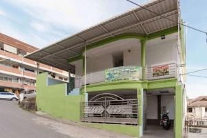 a green and white building with a balcony at KoolKost near Nagoya Hill Batam (Minimum Stay 30 Nights) in Nagoya