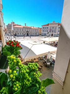 a view of a courtyard with a large white umbrella at Artini Apartments Piran in Piran