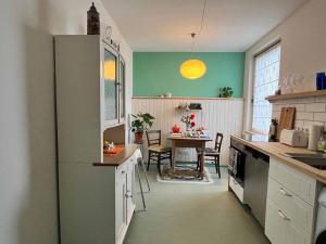 eine Küche mit einem Kühlschrank und einem Tisch darin in der Unterkunft Appartement Sandsteig 1 in Grafenau