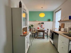 a kitchen with a refrigerator and a table in it at Appartement Sandsteig 1 in Grafenau