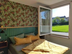 Cama en habitación con ventana y ventana en Appartement Sandsteig 1 en Grafenau