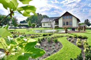 un jardín frente a una casa con un edificio en Auróra Rendezvényterem & Szállás, en Jászapáti