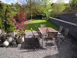 a patio with a table and chairs and a lawn at Le Marronnier in Bouillon